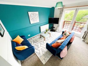 uma sala de estar com duas cadeiras azuis e uma televisão em 2 Bedroom Flat - Free Parking em Shenley Church End