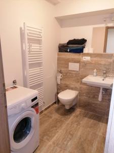 uma casa de banho com uma máquina de lavar roupa e um lavatório em Brand new studio apartment #51 with free secure parking in the center em Praga