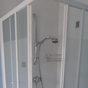 a shower with a shower head in a bathroom at Craig Cottage Self-catering in Bushmills