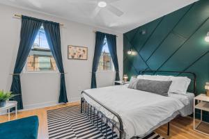 Un dormitorio con una cama con una pared de acento verde en Family Fun South Philly Game House Near Sports Stadiums and Concerts, en Filadelfia