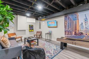 a room with a couch and a large screen at Family Fun South Philly Game House Near Sports Stadiums and Concerts in Philadelphia