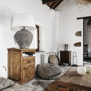 uma sala de estar com um candeeiro numa cómoda de madeira em Cortijo Almarchal em El Almarchal