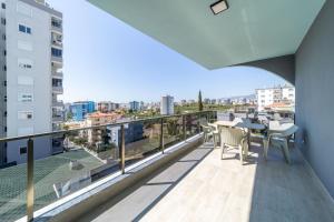 a balcony with a table and chairs and a view of a city at Modern Apartment with Shared Sauna in Alanya in Kargicak