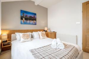 een slaapkamer met een wit bed en 2 slippers erop bij Luxurious Mews House Next to Hyde Park in Londen