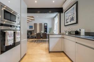 a kitchen with a counter and a living room at Luxurious Mews House Next to Hyde Park in London