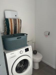 uma casa de banho com uma máquina de lavar roupa e um WC em La landaise em Dax