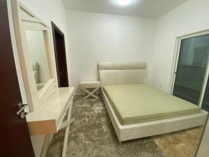 ein kleines Zimmer mit einem Bett und einem Spiegel in der Unterkunft OWN APARTMENT in Ajman 