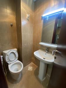 ein Badezimmer mit einem WC, einem Waschbecken und einem Spiegel in der Unterkunft OWN APARTMENT in Ajman 