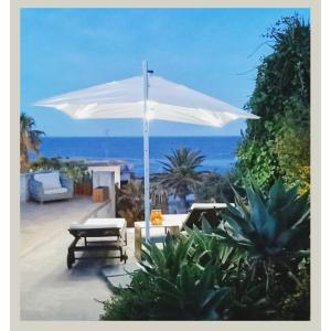 潘泰萊里亞的住宿－Birbiciù mare，白色的伞和背景海洋的长凳