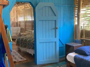 a room with a blue door and a bedroom at Casa Love in Sayulita