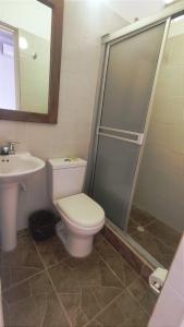 uma casa de banho com um WC, um lavatório e um chuveiro em HOTEL MACEO MELGAR em Melgar