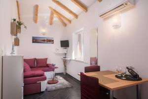 Una sala de estar con una mesa y un sofá rojo. en Apartments Trabakul, en Trogir