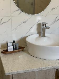 a bathroom counter with a sink and a mirror at LEGENDS EXECUTIVE LODGE in Choma