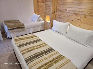 two beds in a hotel room with white sheets at Loft Altos Suite in Puerto Natales +26 photos