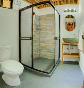 y baño con ducha, aseo y lavamanos. en Sámara Tarantela Houses, Casa Coyol, en Sámara