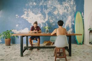 two people sitting at a table with a dog at Puerto Dreams H in Puerto Escondido +57 photos