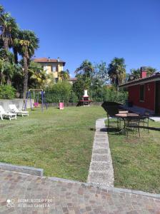 un parque con mesa, sillas y parque infantil en Villetta Primavera, en Verbania