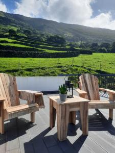 two chairs and a table on a deck with a view at Casa de Santo Amaro in Santo Amaro