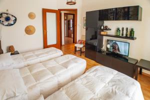 een woonkamer met twee witte banken en een tv bij Attico con Vista in Turijn