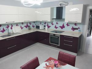 a kitchen with purple butterflies on the wall at Sea ​​view triplex villa in Komera