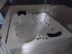 a white bath tub in a bathroom with at Sea ​​view triplex villa in Komera