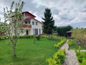 a house with a grassy yard with a tree at Sea ​​view triplex villa in Komera