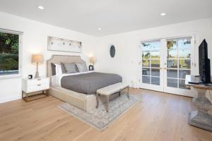 a bedroom with a bed and a tv and windows at Stradella in Los Angeles