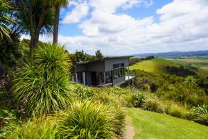 a house on a hill with palm trees at Te Huia in Whangarei Heads