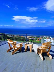 - deux bancs en bois assis sur une terrasse donnant sur l'océan dans l'établissement Casa de Santo Amaro, à Santo Amaro