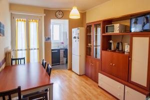 a kitchen with a dining table and a kitchen with a refrigerator at Attico con Vista in Turin
