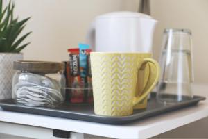 a tray with a coffee mug and other items on a shelf at 4ft Double bed with Parking & Wi-fi in Modern Townhouse in Long Eaton in Long Eaton