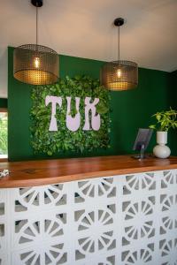 een tucci bord op een groene muur in een restaurant bij TUK Tropical Boutique Resort Jan Thiel in Willemstad