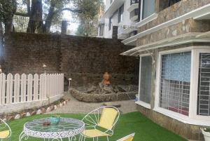 a patio with a table and chairs and a fountain at 2BHK Apartment In Mansion Near Nainital Lake in Nainital