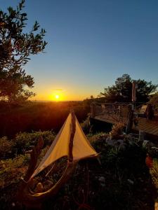 a tent in the grass with the sunset in the background at Villa René in Koskinou