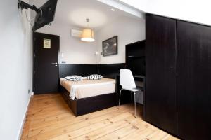 - une chambre avec un lit, un bureau et une chaise dans l'établissement Despertar Saudade, à Coimbra