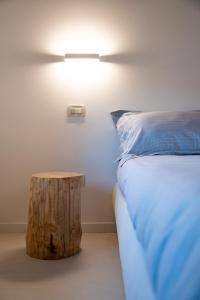 1 dormitorio con 1 cama y un tronco de madera junto a una mesa en Una Rosa sul Mincio, en Valeggio sul Mincio
