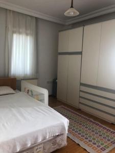 een slaapkamer met een wit bed en een tapijt bij Yazlık in Burhaniye