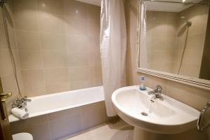 a bathroom with a sink and a bath tub at UN JARDIN EN LA CIUDAD gran piso y super terraza en el centro By Apartamentos con aire acondicionado Logroño in Logroño +21 photos