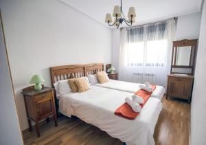 a bedroom with two beds with towels on them at UN JARDIN EN LA CIUDAD gran piso y super terraza en el centro By Apartamentos con aire acondicionado Logroño in Logroño