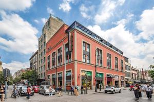 a large brick building on a busy city street at Barrio Downtown Mexico City Hostel in Mexico City