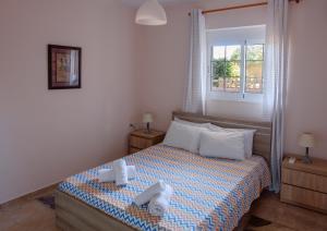 a bedroom with a bed with two towels on it at Seashore Apartments in Chorafakia