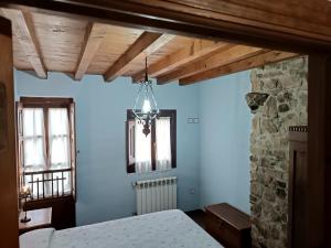 1 dormitorio con cama y pared de piedra en La Casona II de Pravia, en Pravia
