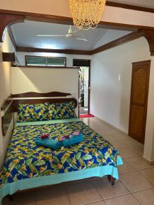 um quarto com uma cama com uma colcha colorida em Bellevue Raiatea em Uturoa