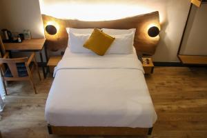 a bedroom with a large bed with a yellow pillow at Taksimbul Design Hotel in Istanbul