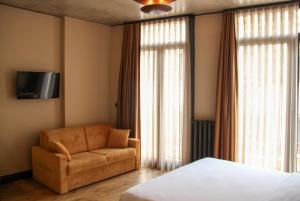 Taksimbul Design Hotel في إسطنبول: غرفة نوم بسرير وكرسي وتلفزيون