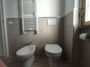 ein kleines Badezimmer mit Toilette und Waschbecken in der Unterkunft Beach House Garden, 300m dal mare, wifi, bici, giardino privato, clima in Marina di Massa