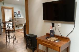 ein Wohnzimmer mit einem Tisch und einem TV an der Wand in der Unterkunft Little Bear Cabin in Woodland Park