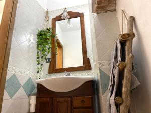 La salle de bains est pourvue d'un lavabo et d'un miroir. dans l'établissement B&B L'angolino, à Usigliano