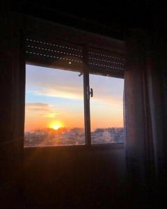 a window with a view of the sunset at Cómodo apartamento en Colonia, cerca de todo in Colonia del Sacramento