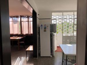 a kitchen with a refrigerator and a table and a dining room at Cómodo apartamento en Colonia, cerca de todo in Colonia del Sacramento